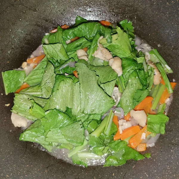 Setelah wortel matang, masukkan sawi dan bumbu penyedap.