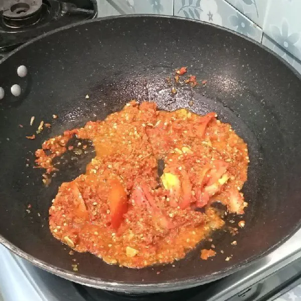 Tumis bawang merah dan bawang putih sampai harum. Setelah harum masukkan bumbu yang sudah dihaluskan dan tomat, tumis hingga harum dan matang