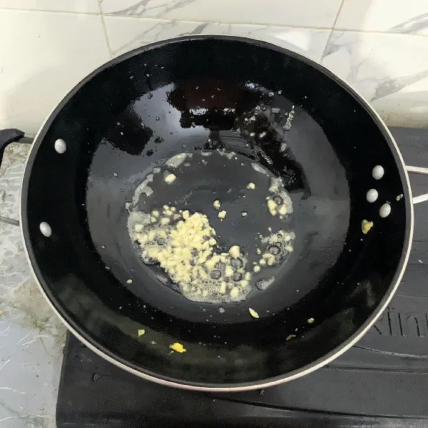 Tumis bawang putih hingga harum dan sedikit layu.