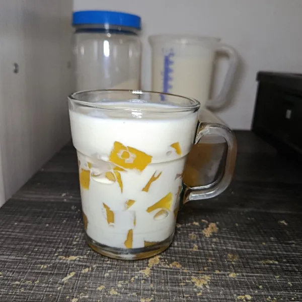 Masukkan pudding mangga dan nata de coco, lalu tuangkan kuah kejunya.