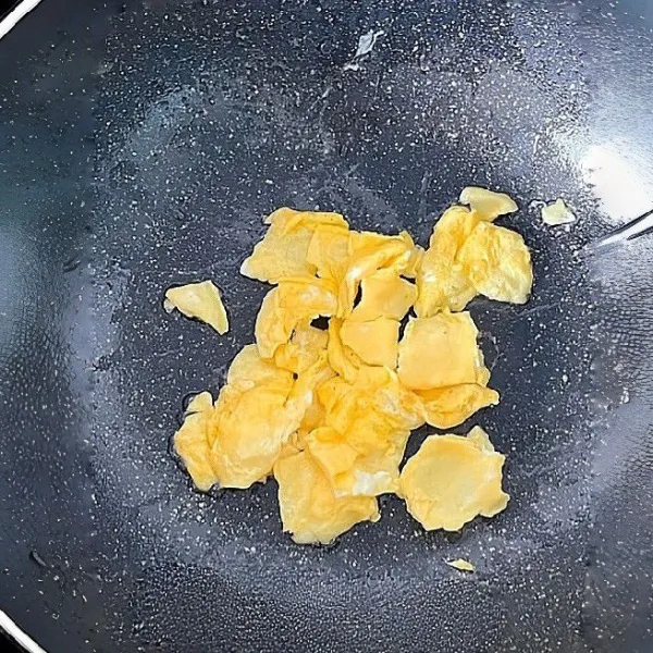 Panaskan minyak goreng, tuangkan 2 butir telur ayam ke dalam wajan dan orak-arik hingga matang. Angkat dan sisihkan