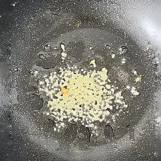 Tambahkan sisa minyak goreng, tumis 10 gr bawang putih cincang hingga harum