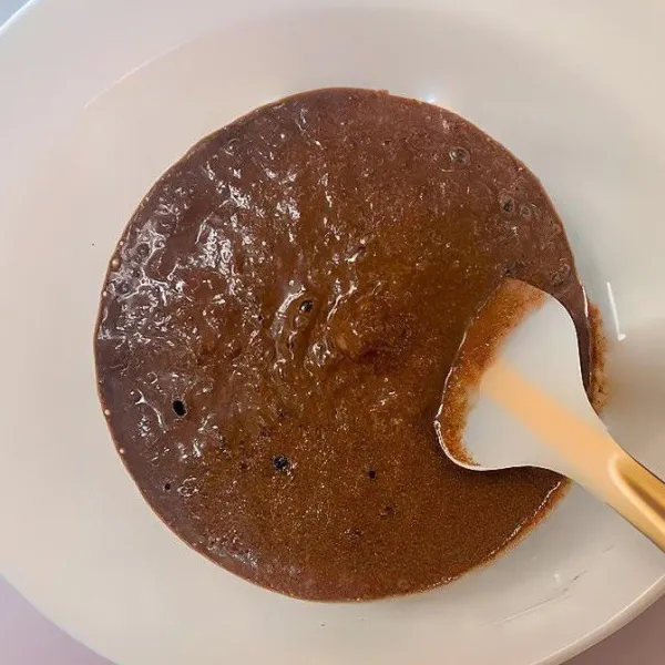 Tambahkan 1 sdm susu kental manis, aduk rata. Tuangkan adonan ke dalam cetakan yang sudah dialasi kertas roti