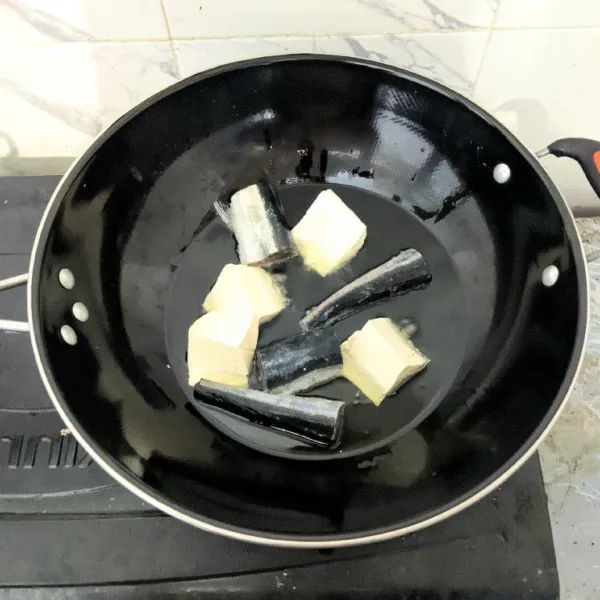 Goreng ikan tuna dan tahu putih hingga setengah matang. Angkat dan tiriskan.