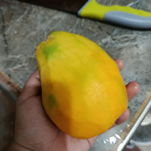 Kupas buah mangga.