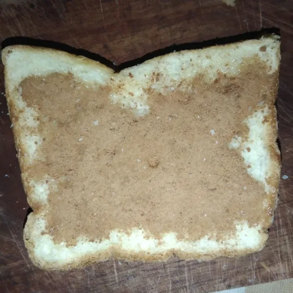 Oleskan susu kental manis dan cokelat bubuk ke roti tawar.