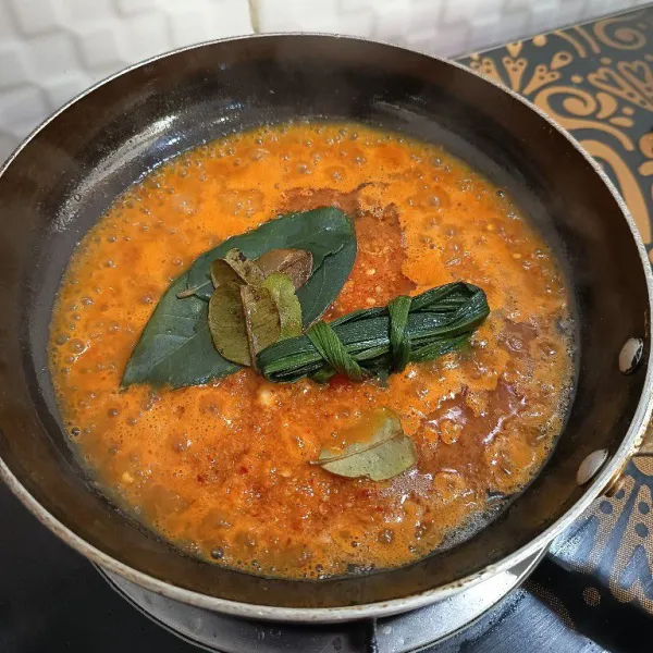 Tumis cabe merah, kunyit, kemiri, jahe, serai, daun salam, daun jeruk, daun pandan, bawang merah, dan bawang putih hingga wangi dan matang.