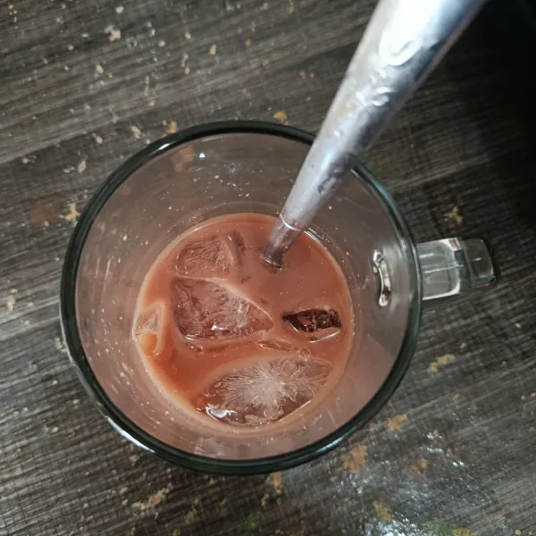 Siapkan gelas saji, masukkan coklat yang sudah di seduh tadi, lalu tambahkan es batu.