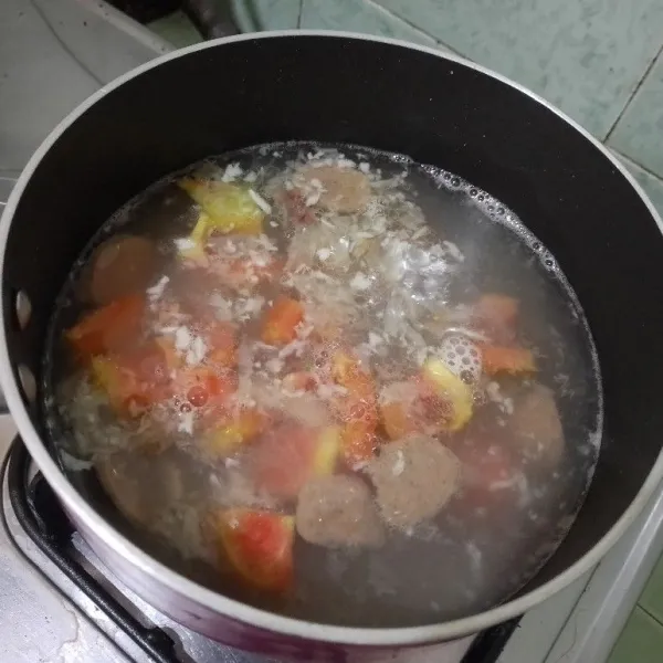 Tambahkan air secukupnya. Bila sudah mendidih masukkan irisan bakso sapi dan potongan tomat merah. Masak hingga mendidih. Aduk rata.