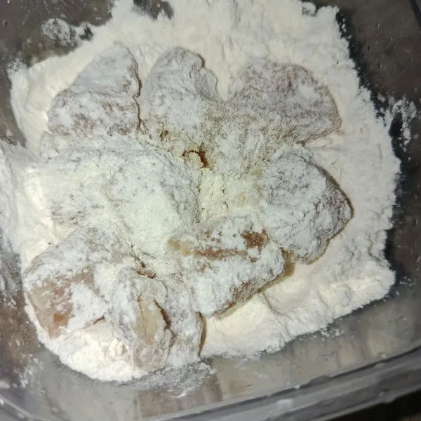 Masukkan ayam ke tepung serbaguna dan balur hingga rata.
