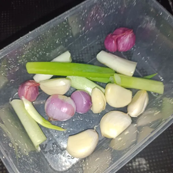 Haluskan bawang putih, bawang merah, dan daun bawang sebagai bumbu halus.