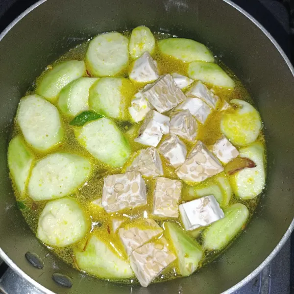 Masukkan tempe yang sudah dipotong dadu sebelumnya, lalu tambahkan daun jeruk, garam, dan kaldu ayam.