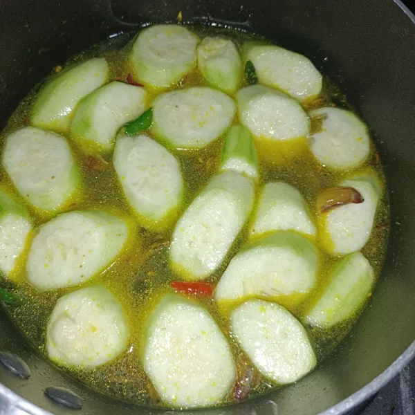 Kupas sayur gambas, lalu potong-potong dan cuci sampai bersih. Masukkan sayur ke kuah yang sudah mendidih.
