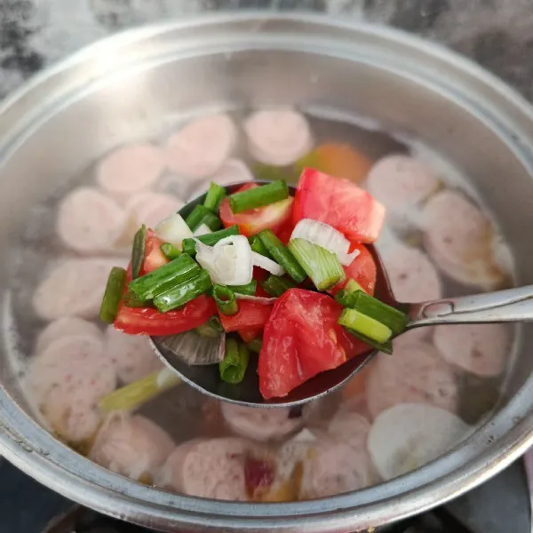 Tambahkan potongan tomat dan irisan daun bawang sesaat sebelum kompor dimatikan.