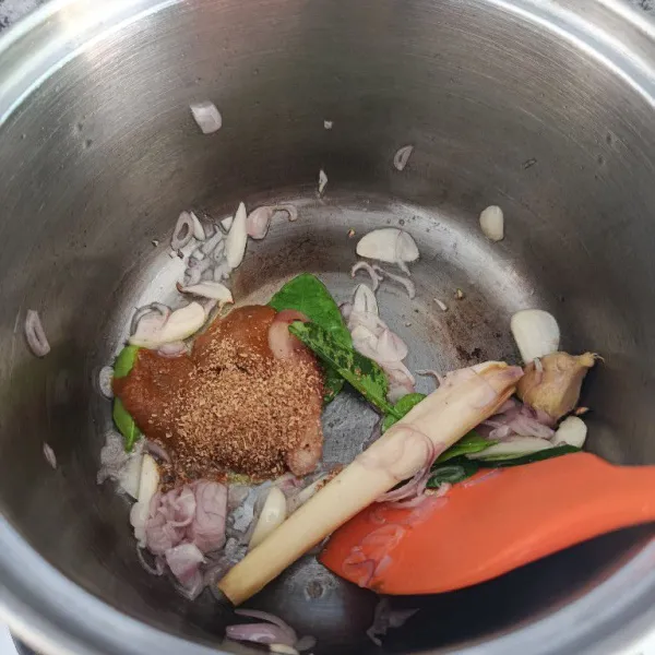 Tambahkan bumbu soto instan, ketumbar bubuk, serai, lengkuas dan daun jeruk purut. Tumis hingga bumbu matang dan tanak.
