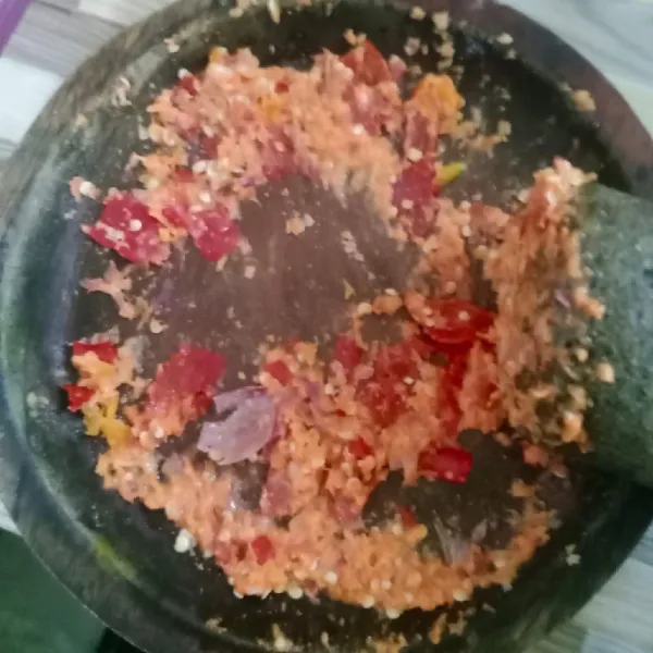 Haluskan bawang merah, bawang putih, cabe rawit, cabe merah keriting dan kemiri.