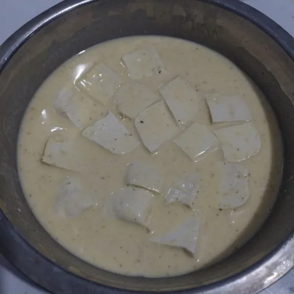 Masukkan tahu yang sudah dipotong-potong ke dalam adonan tepung.