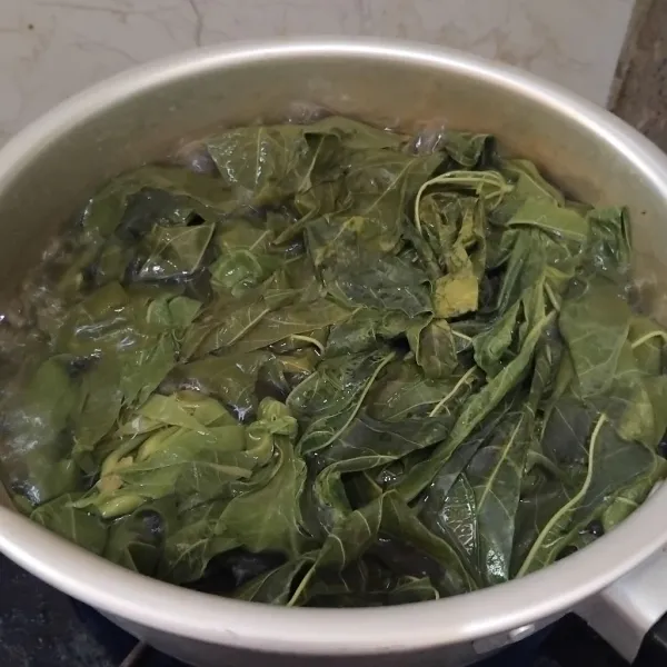 Didihkan air, lalu rebus pucuk daun singkong hingga empuk.
