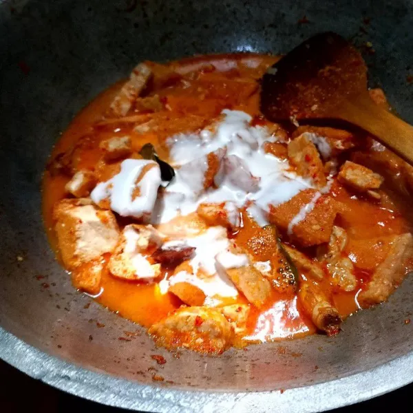 Tuangkan santan, lalu terus aduk hingga santan mendidih.