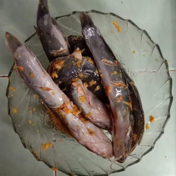 Lumuri bumbu halus pada ikan lele dan diamkan selama 10 menit.