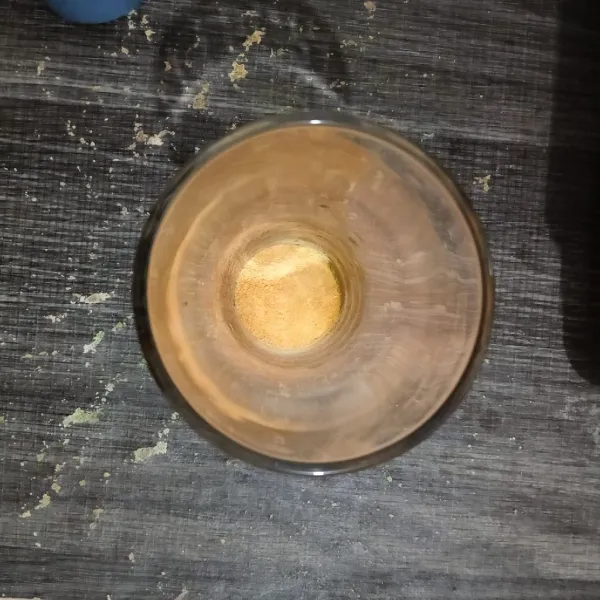 Siapkan gelas, masukkan serbuk minuman rasa jeruk.