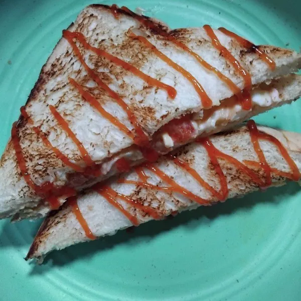 Potong segitiga kemudian beri saos tomat untuk topingnya, sajikan.