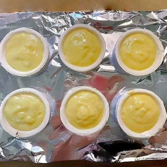 Tuang adonan ke dalam 6 kulit egg tart hingga hampir penuh