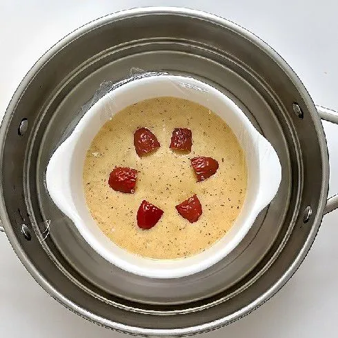 Tutup permukaan mangkuk dengan plastik wrap dan tusuk beberapa lubang kecil. Panaskan kukusan dengan air dingin, kukus adonan selama 20 menit