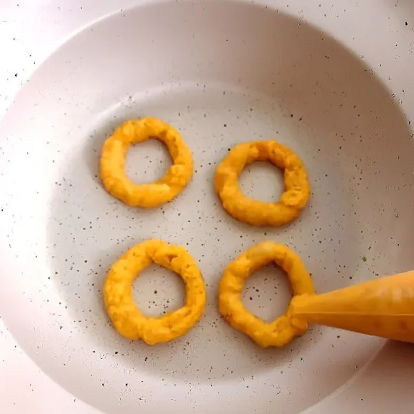 Balik donat menggunakan spatula dan sumpit, lalu masak kembali 3 menit hingga kedua sisi matang merata dan sedikit kecokelatan