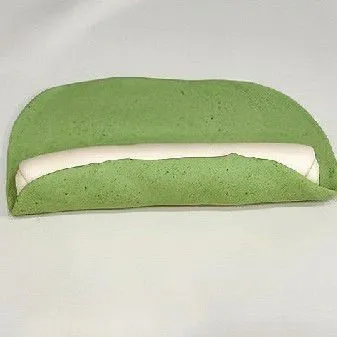 Letakkan gulungan putih di atas lembaran adonan hijau, lalu gulung kembali menjadi satu gulungan besar. Rapikan bentuk adonan agar memanjang dan rapi sebelum difermentasi