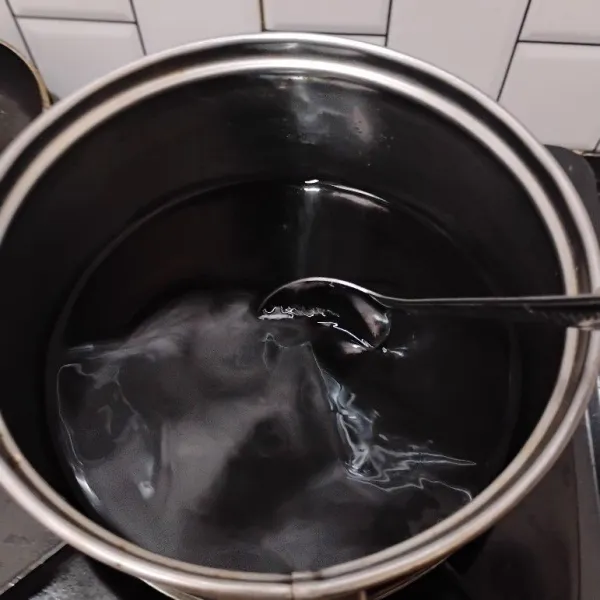 Membuat grass jelly, tuang bubuk jelly, gula pasir, dan air ke dalam panci. Masak hingga meletup-letup.