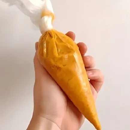 Masukkan adonan ke dalam plastik segitiga dan gunting ujungnya sedikit