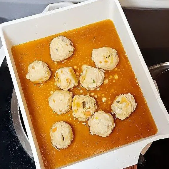 Panaskan sedikit minyak di wajan. Masukkan bakso rebus, tumis hingga permukaannya sedikit kecokelatan. Tuang saus ke dalam wajan, masak dengan api kecil hingga mengental dan membalur bakso secara merata