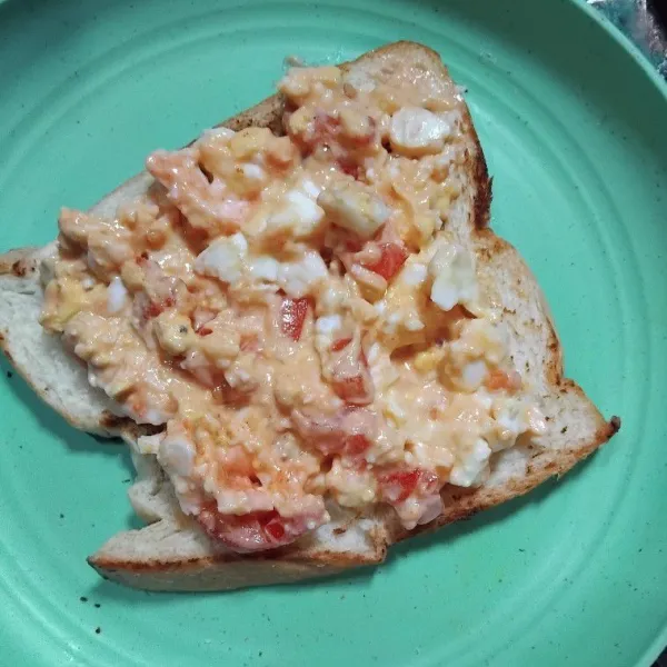 Ambil selembar roti panggang, beri isian, timpa dengan roti satunya.