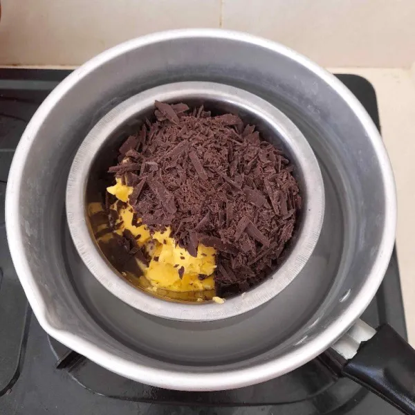 Lelehkan butter dan dark chocolate dengan cara double boiler/tim