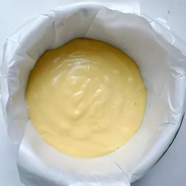 Tuang adonan ke loyang yang sudah dialasi baking paper. Siapkan loyang lebih besar, isi air hangat setinggi ±1 cm, letakkan loyang adonan di atasnya