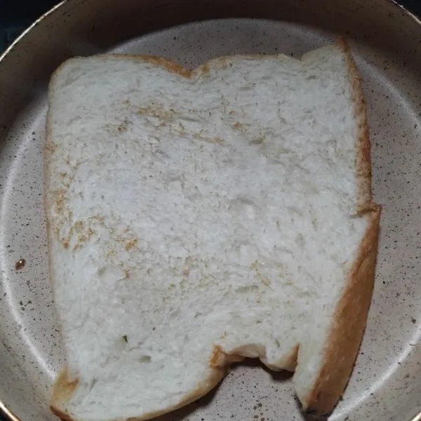 Panaskan teflon, beri margarin kemudian panggang roti hingga kedua sisinya kecoklatan.
