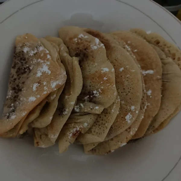 Jika sudah matang, pindahkan ke piring saji, beri isian susu kental manis dan gula halus, kemudian lipat terang bulan jadul eggless, lalu sajikan selagi hangat 🥰